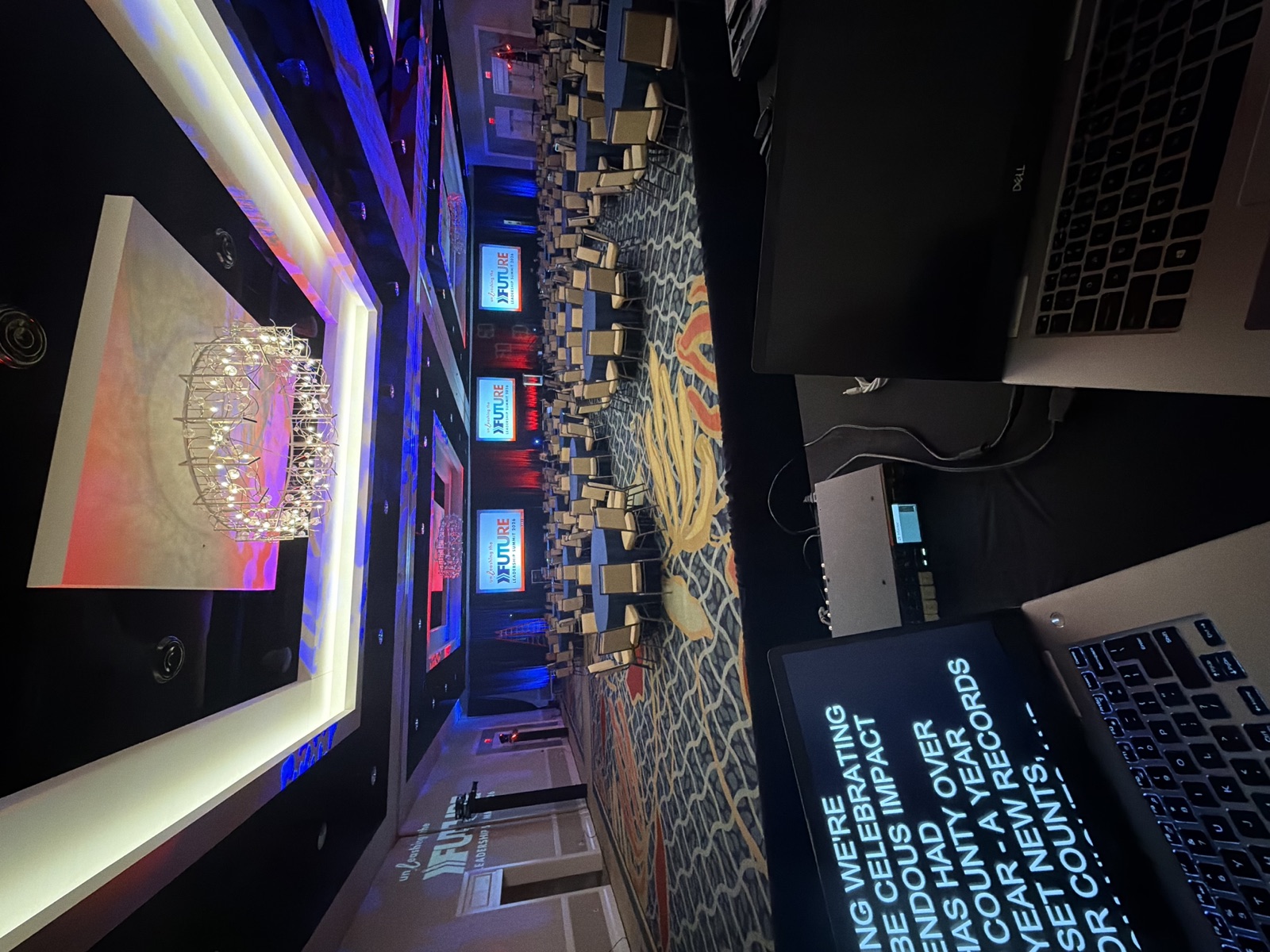 Operator station with teleprompter laptops facing a ballroom stage